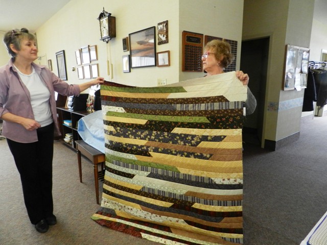 Climax branch members assessing a quilt